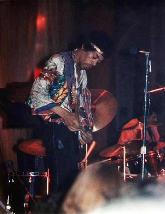 Jimi Hendrix bent over his guitar on stage on 20 June 1970, during his last American tour, photographed from the audience.