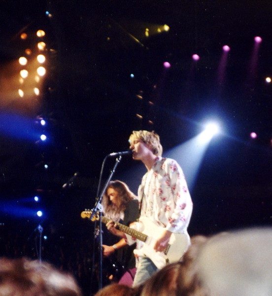 Kurt Cobain singing and playing guitar, with Krist Novoselic on bass behind him, live at the MTV Video Music Awards in Los Angeles, 9 September 1992.