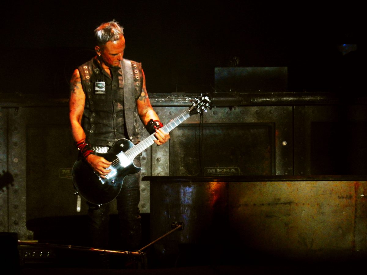 Rhythm guitarist Paul Landers playing a black single-cutaway guitar in the Arena of Nîmes, France, 13 July 2017.