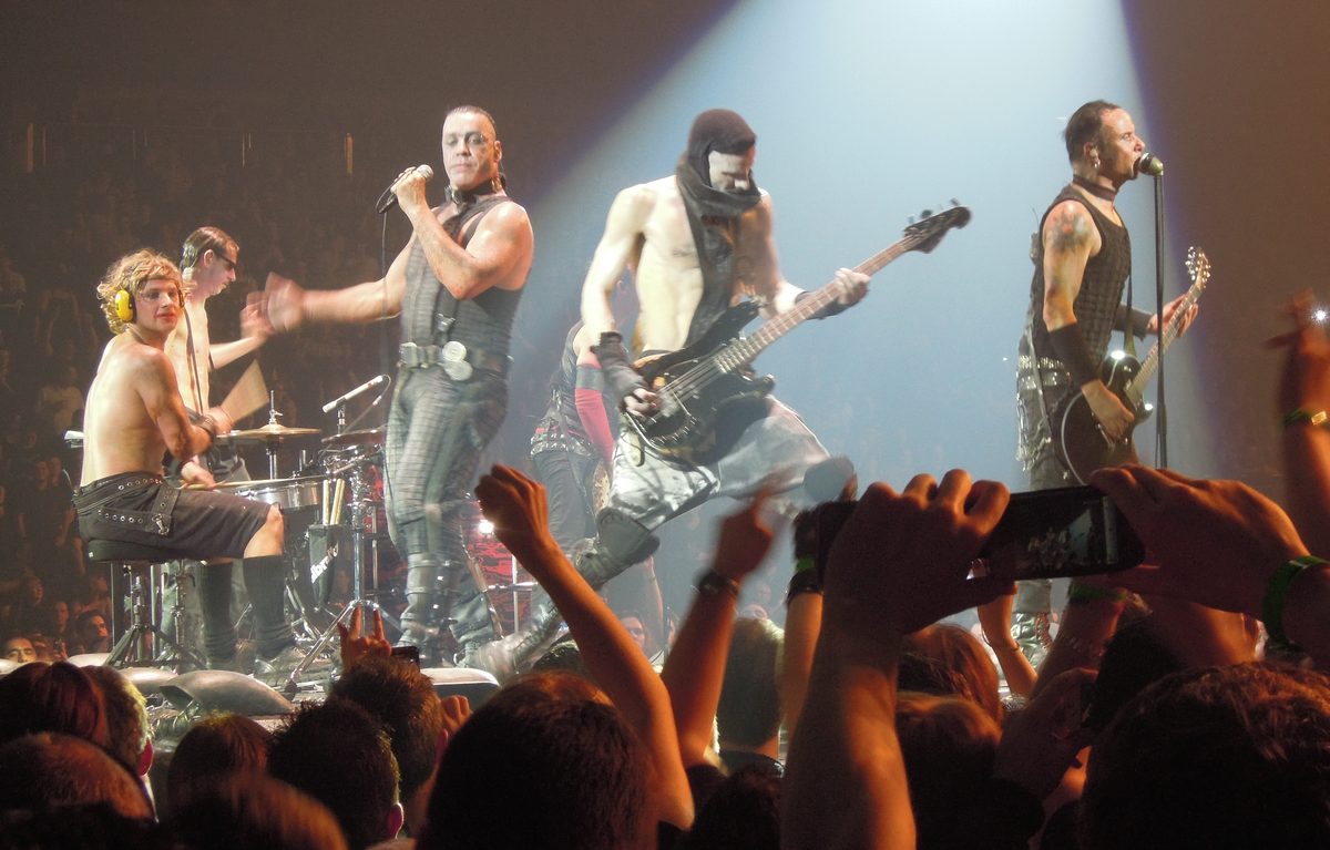 Rammstein on the small stage at the O2 Arena, London, 24 February 2012, playing Bück dich: Till Lindemann in the centre, bassist Oliver Riedel and guitarist Paul Landers to the right.