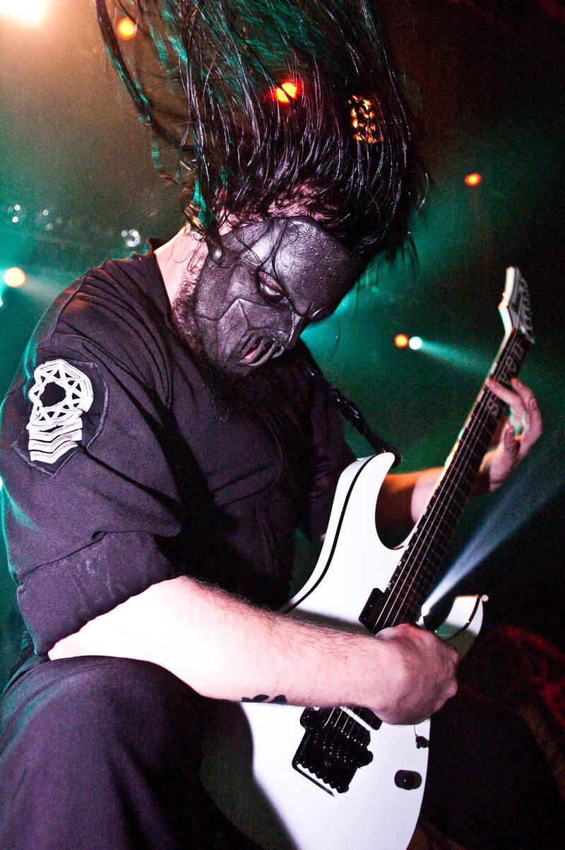 Mick Thomson headbanging over his white Ibanez guitar on stage with Slipknot in 2005.