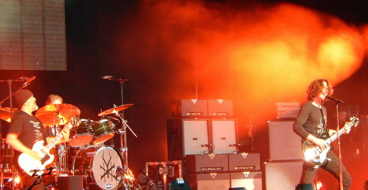 Kim Thayil and Chris Cornell playing guitars side by side at a Soundgarden show in July 2014, Matt Cameron behind them.